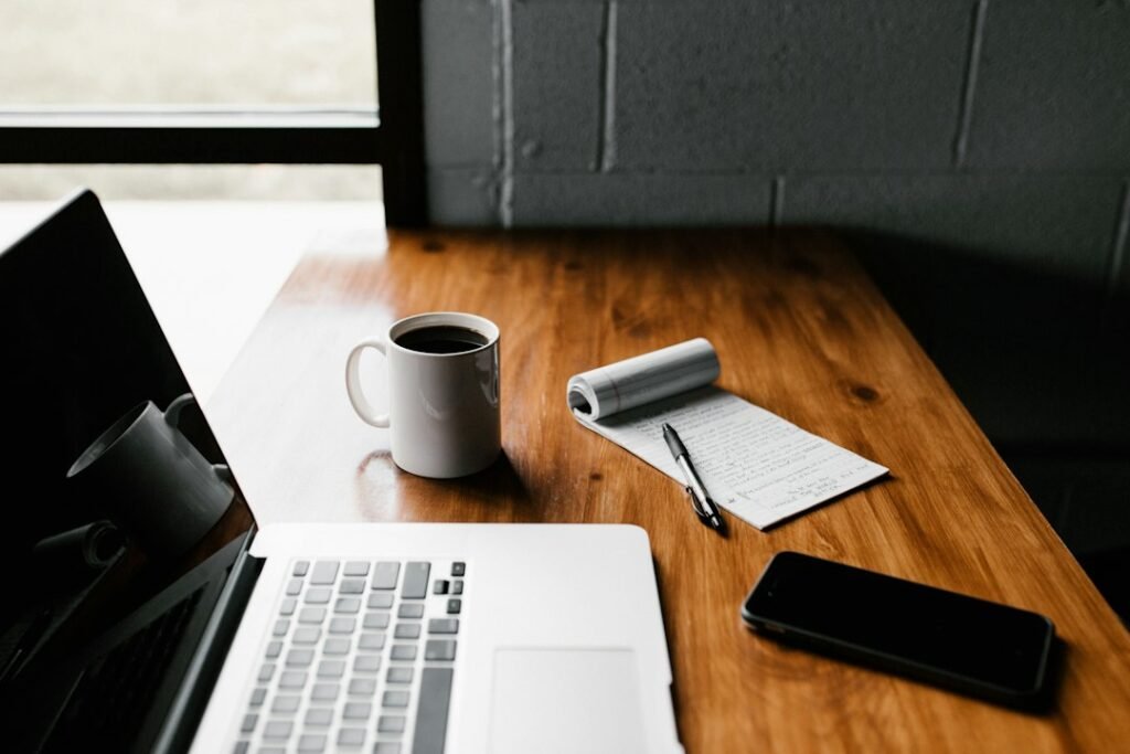 Blog writing workspace with a laptop, notebook and coffee