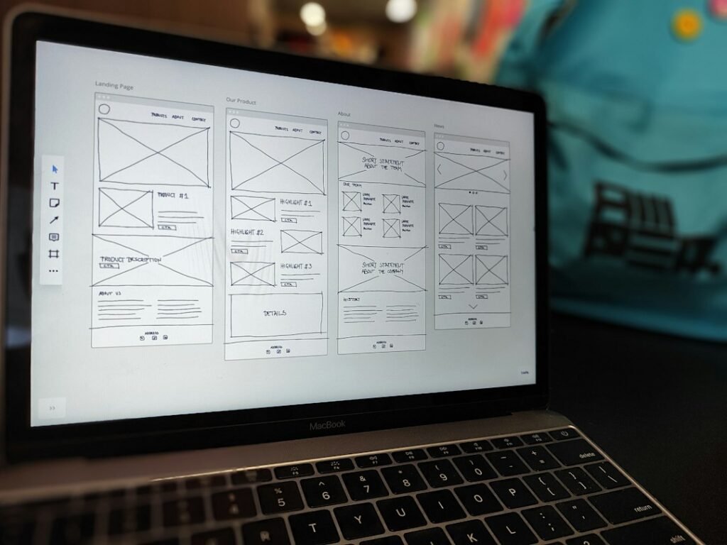 Laptop displaying a website wireframe during a redesign planning session